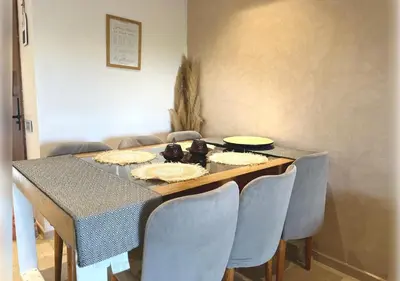 a dining room table with chairs and a table with food on it at Ehden Properties - Appt d'exception dans l'incontournable Prestigia in Marrakech