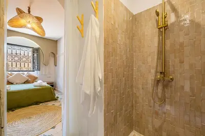 a bathroom with a shower and a bed in a room at Riad Dar Mimouna -Exclusive&Brand new -Pool- 8pax in Marrakech