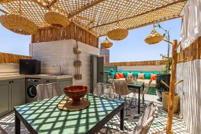 a patio with a table and chairs and a kitchen at Riad Dar Mimouna -Exclusive&Brand new -Pool- 8pax in Marrakech