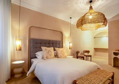 a bedroom with a large white bed and two lights at Apartment in Gueliz, Riad style, equipped and central in Marrakech
