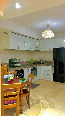 a kitchen with a table and a black refrigerator at 5-Star Hidden Gem in Marrakech in Marrakech