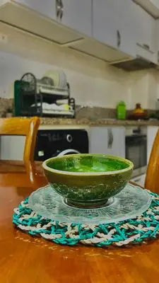 a green bowl on a glass plate on a table at 5-Star Hidden Gem in Marrakech in Marrakech