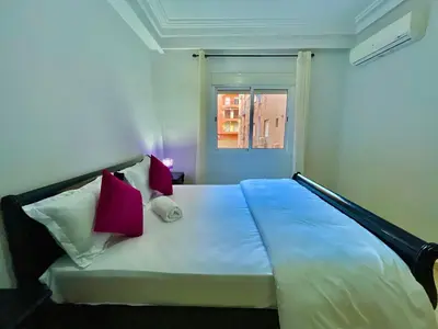a bedroom with a bed with pink and white pillows at 5-Star Hidden Gem in Marrakech in Marrakech