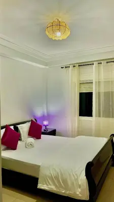 a bedroom with a large white bed with red pillows at 5-Star Hidden Gem in Marrakech in Marrakech