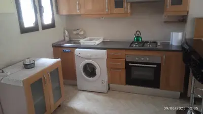 a kitchen with a washing machine and a stove at A Cosy Maison avec un accès direct à la piscine in Marrakech