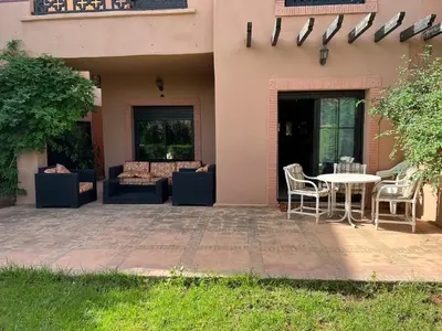 a patio with couches and a table in a house at A Cosy Maison avec un accès direct à la piscine in Marrakech