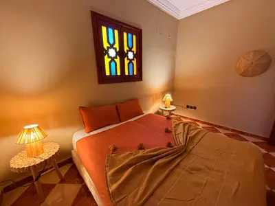 a bedroom with a bed and a stained glass window at DAR ENNAGA - Havre de paix, avec piscine chauffée , à 10 minutes de Marrakech in Marrakech