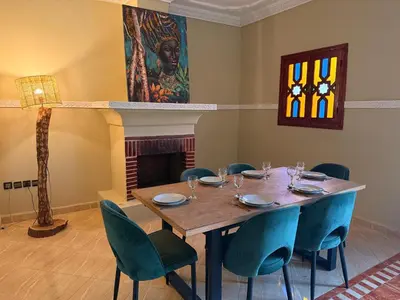 a dining room with a wooden table and chairs at DAR ENNAGA - Havre de paix, avec piscine chauffée , à 10 minutes de Marrakech in Marrakech