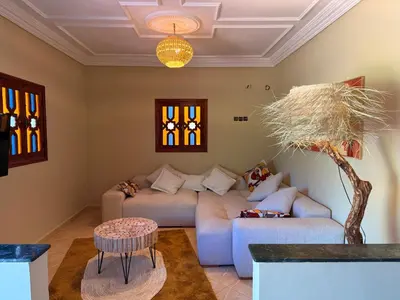 a living room with a couch and a table at DAR ENNAGA - Havre de paix, avec piscine chauffée , à 10 minutes de Marrakech in Marrakech