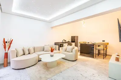 a living room with a white couch and a table at Duplex Confort, Jacuzzi à 5min de Majorelle&Médina in Marrakech