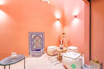a room with tables and chairs and a fireplace at Duplex Confort, Jacuzzi à 5min de Majorelle&Médina in Marrakech