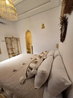 a bedroom with a large bed with white pillows at Dar laarbi Kasbah in Marrakech