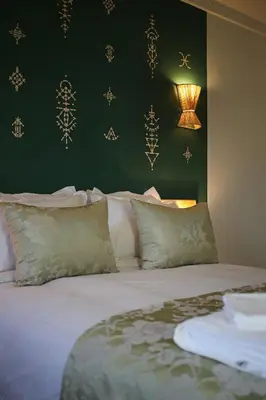 a bed with white pillows and a green wall at Spacious 3Br Apartment-Pool&AC- Heart of Marrakech- Hivernage in Marrakech