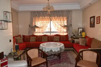 a living room with a red couch and a table at Marrakech Sakan Annakhil im6 n31 in Marrakech