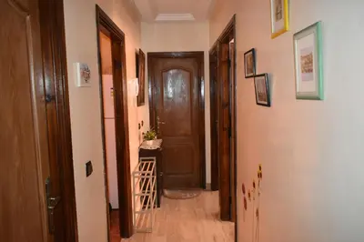 a hallway with a brown door and a table at Marrakech Sakan Annakhil im6 n31 in Marrakech