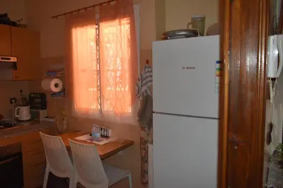 a kitchen with a white refrigerator and a table with chairs at Marrakech Sakan Annakhil im6 n31 in Marrakech