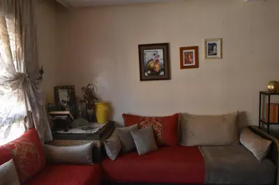a living room with a red couch with pillows at Marrakech Sakan Annakhil im6 n31 in Marrakech
