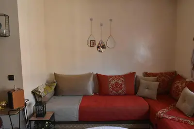 a living room with a red couch with pillows at Marrakech Sakan Annakhil im6 n31 in Marrakech