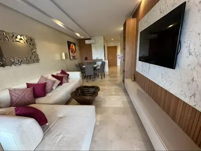 a living room with a couch and a television on a wall at Appartement Marrakech in Marrakech