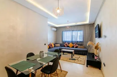 a living room with a table and a couch at Gueliz Train Station - Swimming Pool - Cosy in Marrakech