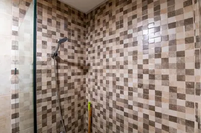 a shower in a bathroom with a tiled wall at Gueliz Train Station - Swimming Pool - Cosy in Marrakech