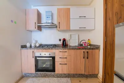 a kitchen with wooden cabinets and a stove at Gueliz Train Station - Swimming Pool - Cosy in Marrakech