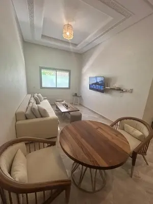 a living room with a table and a couch at Appartement Haut Standing in Marrakech