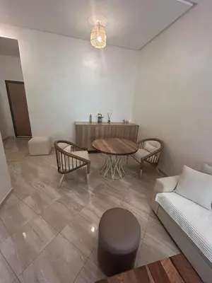 a living room with a table and a couch at Appartement Haut Standing in Marrakech