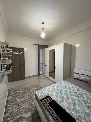 a large room with a bed and a refrigerator at Jardin chrifiya in Marrakech