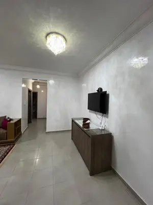 a living room with a tv on a white wall at Jardin chrifiya in Marrakech
