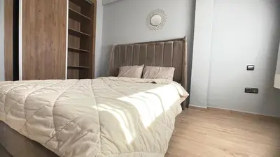 a bedroom with a large bed with a wooden headboard at Lovely apartment N15 in Marrakech