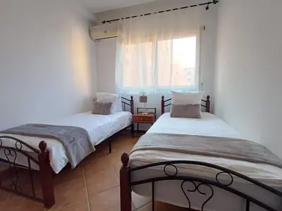 two beds in a room with a window at Gueliz Appartement in Marrakech
