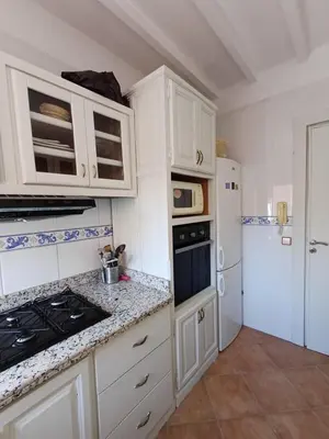 a kitchen with white cabinets and a stove and refrigerator at Gueliz Appartement in Marrakech