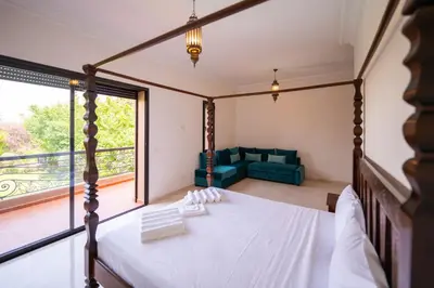 a bedroom with a bed and a large window at Villa Jnan Targa Pool & Garden in Marrakech
