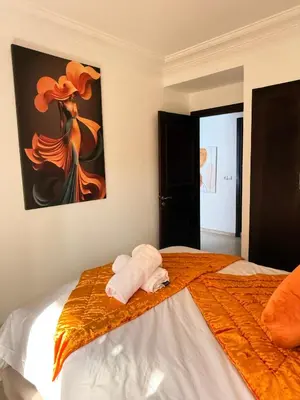 a bedroom with a bed with a painting on the wall at Appartement Moderne & Spacieux au Cœur de Guéliz et Proche Majorelle in Marrakech