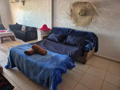 a living room with a blue bed and a couch at Appartement 6 personnes piscine hivernage Marrakech in Marrakech