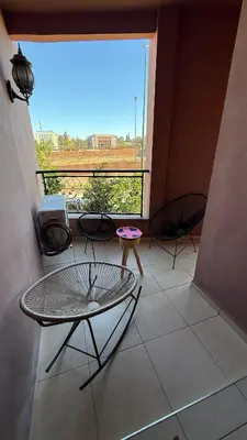 a room with three chairs and a large window at Appartement 6 personnes piscine hivernage Marrakech in Marrakech