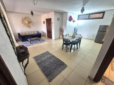 a living room with a table and a couch at Appartement 6 personnes piscine hivernage Marrakech in Marrakech