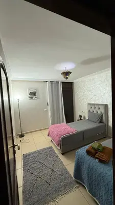 a bedroom with two beds and a rug at Appartement 6 personnes piscine hivernage Marrakech in Marrakech