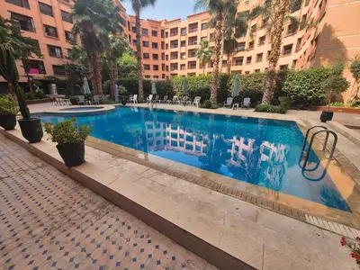 a swimming pool in the middle of a building at Appartement 6 personnes piscine hivernage Marrakech in Marrakech