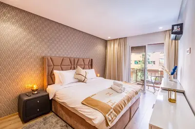 a bedroom with a large bed and a balcony at Joli cocon à Marrakech Balcon privé et confort in Marrakech