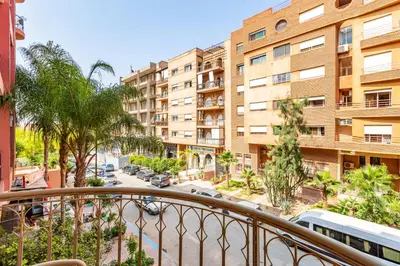 an apartment balcony with a view of a street and buildings at Joli cocon à Marrakech Balcon privé et confort in Marrakech