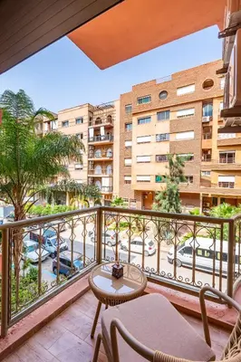 a balcony with a table and chairs and a building at Joli cocon à Marrakech Balcon privé et confort in Marrakech