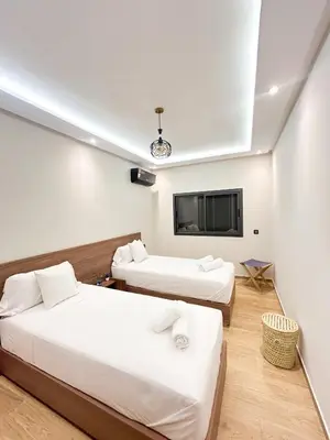 a hotel room with two beds and a tv at Menara Prestige Duplex 4BR with Pool Access in Marrakech