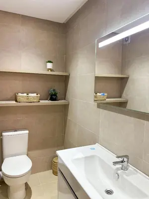 a bathroom with a toilet and a sink and a mirror at Menara Prestige Duplex 4BR with Pool Access in Marrakech