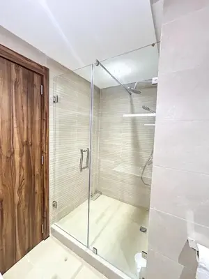 a shower with a glass door in a bathroom at Menara Prestige Duplex 4BR with Pool Access in Marrakech