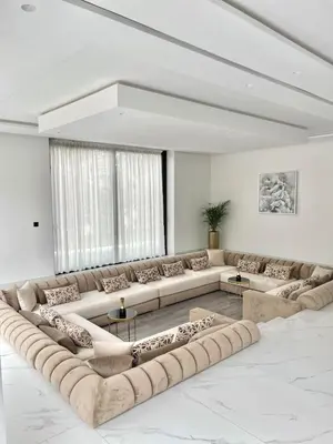 a large living room with long couches and tables at Villa PALM GOLF AMELKIS in Marrakech