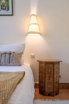 a bedroom with a bed and a nightstand with a lamp at Chez fatina in Marrakech