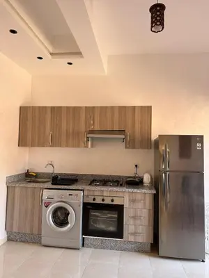 a kitchen with a refrigerator and a washer and dryer at Studio Cosy Proximité Confort in Marrakech