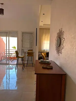 a kitchen and living room with a table and chairs at Studio Cosy Proximité Confort in Marrakech